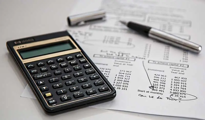 Calculator and pen resting on a printed sheet of investment figures, representing the return on networking