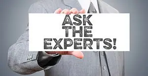 Man in a grey suit holding a sign reading "Ask the experts!" to show you learn your marketplace over time